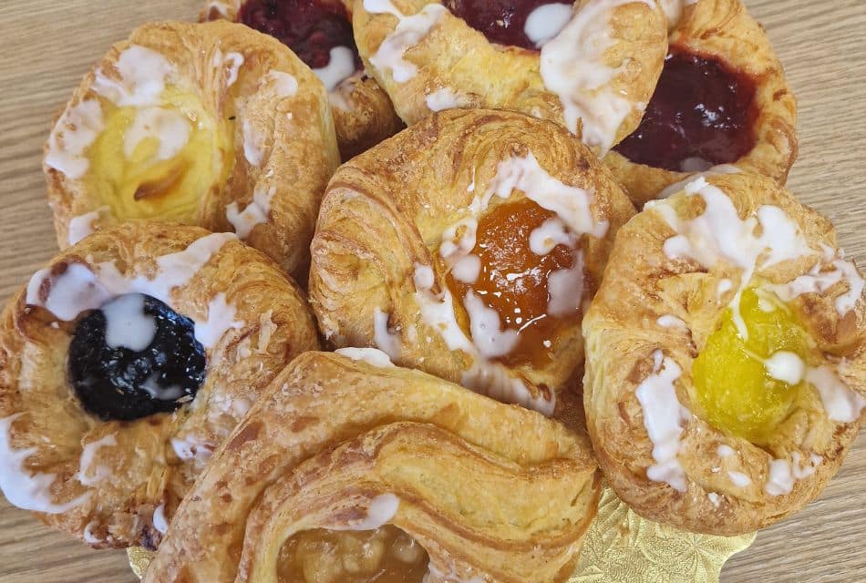 Plate of danishes with different types of fruit on a wood table