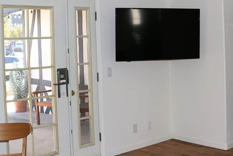 Kitchenette area with TV, wood table and chair and French door to an outside porch