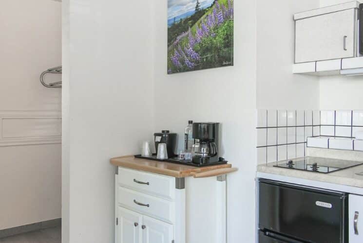 Kitchenette area with tiled backsplash, coffee bar, sink, mini fridge and overhead miicrowave